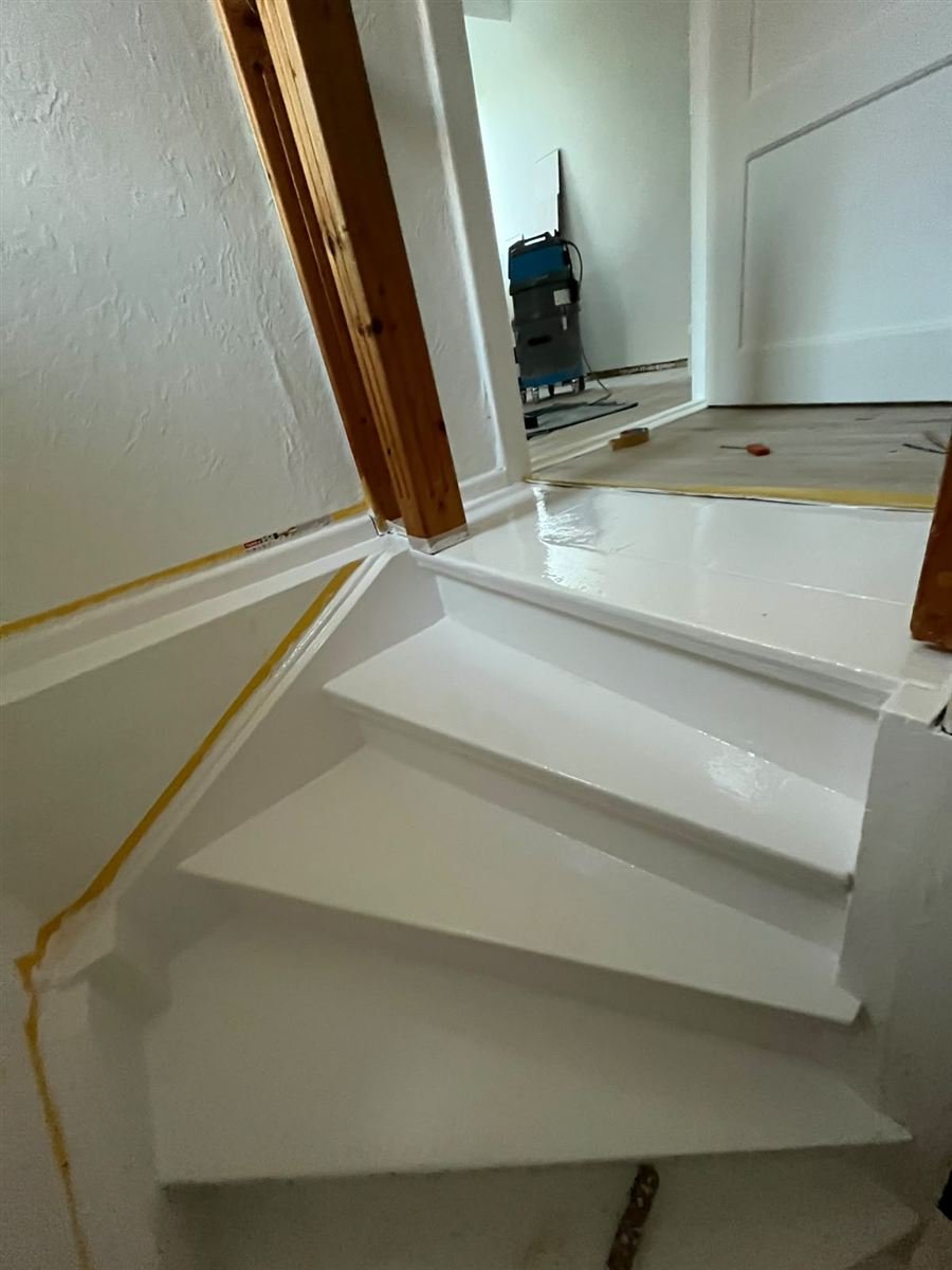 Treppenaufgang mit Holzgeländer, frisch gestrichen